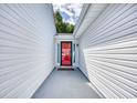 Covered entryway featuring a vibrant red door with glass accents and white siding at 1161 Ganton Way, Myrtle Beach, SC 29588