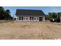 View of the back exterior featuring white sheathing and sliding glass doors at 1280 Highway 45, Loris, SC 29569