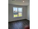 Bright bedroom with hardwood flooring, white trim, and a large window overlooking the outdoors at 191 Glengrove Lane, Murrells Inlet, SC 29576