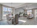 Bright, open-concept living and dining area with large windows, modern chandelier and luxury vinyl flooring at 191 Glengrove Lane, Murrells Inlet, SC 29576
