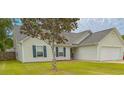 Inviting single-story home with green lawn, a tree, and a two car garage at 445 Saint Charles Circle, Myrtle Beach, SC 29588