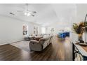 Open-concept living room with a vaulted ceiling, wood floors, a ceiling fan and a modern sofa at 445 Saint Charles Circle, Myrtle Beach, SC 29588