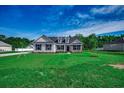 Expansive front lawn leading up to a charming home, set against a clear blue sky at 646 Sunny Pond Ln., Aynor, SC 29511