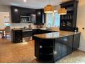Modern kitchen with black cabinets, stainless steel appliances, and countertops with breakfast bar at 133 Otter Run Rd., Pawleys Island, SC 29585