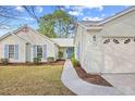 Inviting single-story home with tidy landscaping, light siding, and a cheerful blue front door at 1001 Cardinal Ct., Murrells Inlet, SC 29576