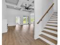 Open-concept living space with coffered ceilings, a fireplace, and natural wood staircase at 144 Sago Palm Dr., Myrtle Beach, SC 29579