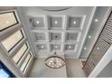 Elegant foyer featuring a coffered ceiling, modern chandelier, and staircase with iron railings at 2417 Gist Ln., Myrtle Beach, SC 29588