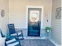 Cozy front porch features rocking chairs, outdoor rug, and stylish decor near the front door at 256 Copper Leaf Dr., Myrtle Beach, SC 29588