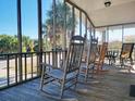 Inviting screened porch with rocking chairs overlooking tropical scenery at 312 Norris Dr., Pawleys Island, SC 29585