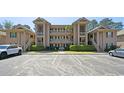 Condo complex with well-maintained parking area, surrounded by lush greenery at 366 Pinehurst Ln. # 13E, Pawleys Island, SC 29585