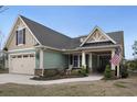 Charming home featuring a two-car garage, well-manicured lawn, and inviting front porch at 4228 Ravenwood Dr., Little River, SC 29566