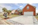 Well-maintained home featuring a wide driveway with decorative paving accents and palm trees at 432 Highfield Loop, Myrtle Beach, SC 29579