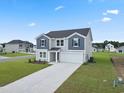 Two-story home with gray siding, dark shutters, and a long paved driveway at 44 Cape Point Dr., Conway, SC 29527