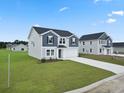 Two-story home featuring gray siding, a well-manicured lawn, and a paved driveway at 44 Cape Point Dr., Conway, SC 29527