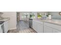 Bright kitchen with stainless steel appliances, white cabinetry, and a view of the adjacent breakfast nook and backyard at 4476 East Coast Ln., Shallotte, NC 28470