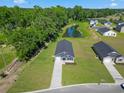 Aerial view of a home near a pond with manicured lawns and surrounding trees at 48 Cape Point Dr., Conway, SC 29527