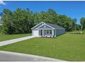 Landscaped home with gray siding, a well-manicured lawn, and an adjacent pond at 48 Cape Point Dr., Conway, SC 29527
