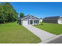Well-manicured home with gray siding, a concrete driveway, and lush green lawn at 48 Cape Point Dr., Conway, SC 29527