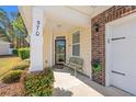 Inviting front porch featuring a cozy bench, brick accents, and well-maintained landscaping for a welcoming entrance at 570 Botany Loop Murrells Inlet # 570, Murrells Inlet, SC 29576