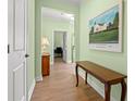 Elegant hallway with light green walls, wood flooring, and stylish decor, leading to other rooms in the home at 570 Botany Loop Murrells Inlet # 570, Murrells Inlet, SC 29576