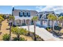 Angle view of gray home with a three-car garage and manicured front lawn at 6121 Bolsena Place, Myrtle Beach, SC 29572