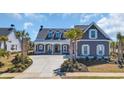 Daytime view of a charming home with a manicured lawn and concrete driveway at 6121 Bolsena Place, Myrtle Beach, SC 29572