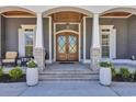 Elegant home entry featuring a gorgeous wooden front door and well-manicured flower pots at 6121 Bolsena Place, Myrtle Beach, SC 29572