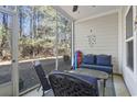 A cozy screened porch with seating and views of the wooded area at 6253 Catalina Dr. # 713, North Myrtle Beach, SC 29582