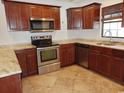 A well-lit kitchen boasts stainless steel appliances, warm wood cabinetry, and granite countertops at 6654 Wisteria Dr., Myrtle Beach, SC 29588