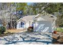 Exterior view of a home with a white garage door and well-maintained landscaping around the foundation at 81 Safe Harbor Ave., Pawleys Island, SC 29585