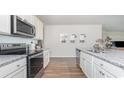 Open kitchen featuring stainless steel appliances, granite countertops, and a seamless flow to the living area at 886 Farmers Passage Loop, Loris, SC 29569