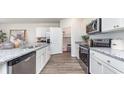 Modern kitchen with white cabinets, stainless steel appliances, granite countertops, and a convenient pantry at 886 Farmers Passage Loop, Loris, SC 29569