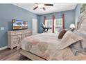 Cozy bedroom boasting plush bedding, wood floors, and abundant natural light from the windows at 329 Lake Mist Ct., Longs, SC 29568