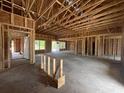 Unfinished living room shows the wooden framework, exposed ceiling beams, and a door leading to the yard at 471 Highway 348, Loris, SC 29569