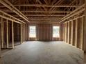 Unfinished living room shows the wooden framework, exposed ceiling beams and two windows at 471 Highway 348, Loris, SC 29569
