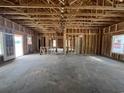 Unfinished living room with wooden framework, exposed ceiling beams, and a door leading to the yard at 471 Highway 348, Loris, SC 29569