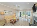 Bright living room featuring a fireplace, ceiling fan, and sliding glass doors to the outside patio at 110-4 White Tail Way # 4, Pawleys Island, SC 29585