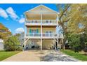 Inviting two-story yellow beach house with charming double balconies at 134 Vista Dr., Murrells Inlet, SC 29576