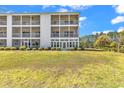 The back of the condo reveals expansive screened porches overlooking lush grassy common area surrounded by tall mature trees at 1505 Lanterns Rest Rd. # 101, Myrtle Beach, SC 29579