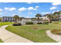 Community pool with palm trees, lush landscaping and several condos in the background on a sunny day at 1505 Lanterns Rest Rd. # 101, Myrtle Beach, SC 29579