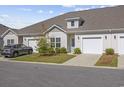 Charming townhome featuring a well-maintained lawn, front door wreath, and an attached one car garage at 154 Sea Shell Dr. # 16, Murrells Inlet, SC 29576