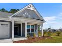 Inviting front porch with craftsman columns and beautiful landscaping at 2191 Gooseberry Way, Longs, SC 29568