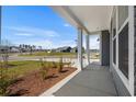Spacious covered porch with scenic views of the neighborhood at 2191 Gooseberry Way, Longs, SC 29568