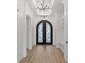 Light-filled entryway featuring beautiful wood flooring, white shiplap, and a stylish, decorative front door at 311 73Rd Ave. N, Myrtle Beach, SC 29572