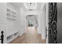 Bright foyer with hardwood floors, shiplap walls, chandelier, and built-in storage at 311 73Rd Ave. N, Myrtle Beach, SC 29572