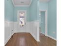 Inviting foyer features elegant wainscoting, wood floors, and a front door with glass insert at 351 Firenze Loop, Myrtle Beach, SC 29579