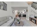 A modern, open living room featuring light wood floors, a staircase, and views to a kitchen at 400 Cambridge Circle # L-7, Murrells Inlet, SC 29576