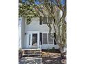 Exterior of a two-story home featuring a front door with sidelights, black shutters, and mature tree at 4115 Little River Rd. # 10-B, Myrtle Beach, SC 29577