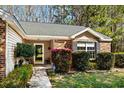 Inviting front entrance with a neatly landscaped garden, brick accents, and a charming pathway to the front door at 4195 Wrens Crossing, Little River, SC 29566
