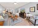 Comfortable living room with a view into the dining area, featuring a large television and modern furnishings at 45 Pinehurst Ln. # 2G, Pawleys Island, SC 29585